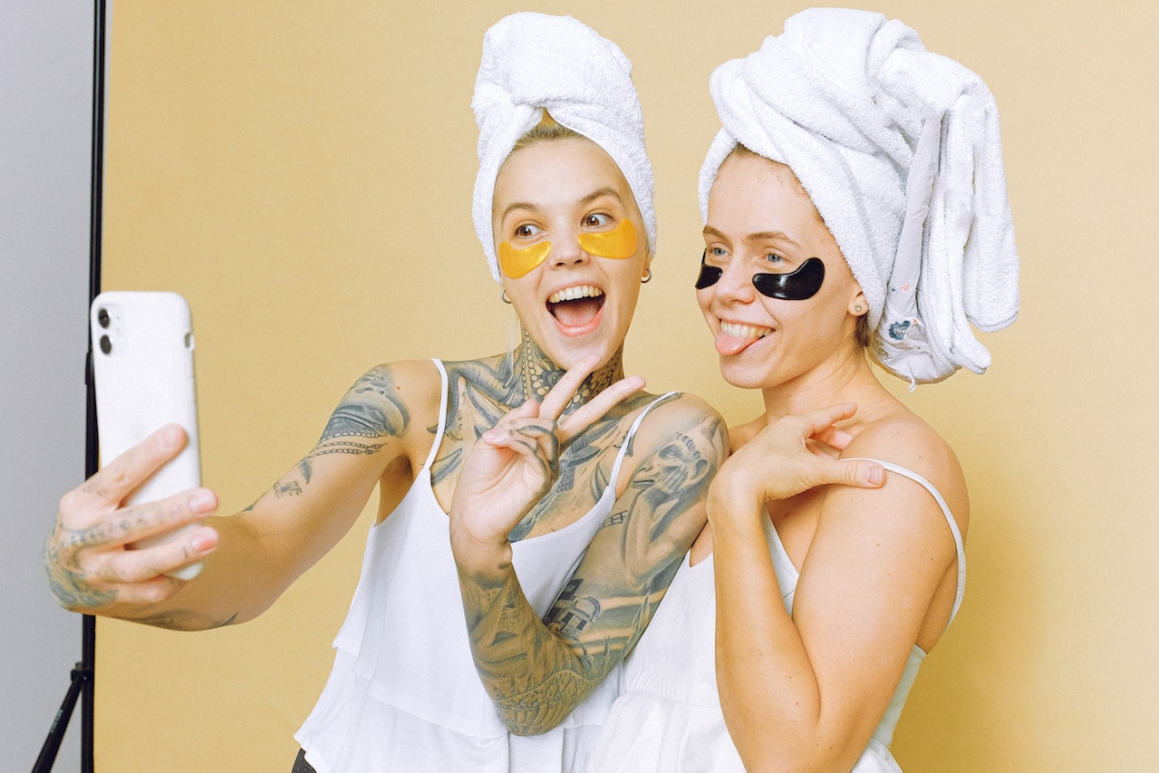 mujeres tomandose un selfie mientras se cuidan la piel